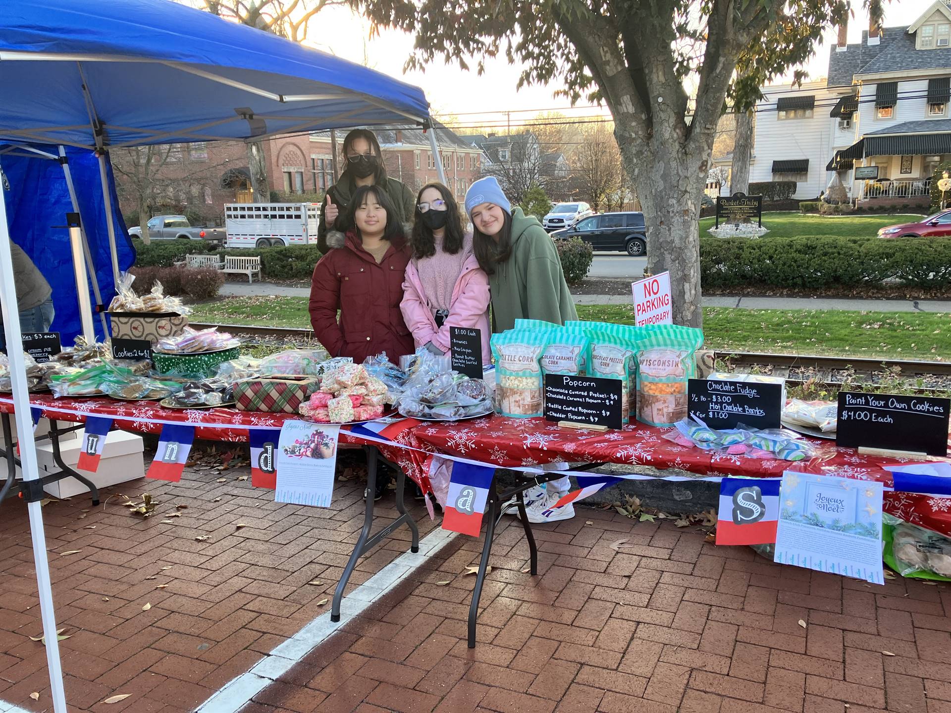 Riverview French Club holding a baking fundraiser. The table is lined with numerous baked goods as f
